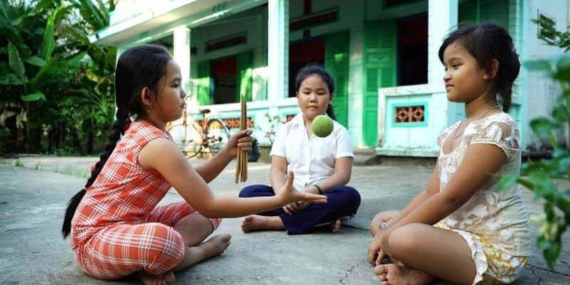 Thẩy banh lên và tay còn lại bắt lấy đũa